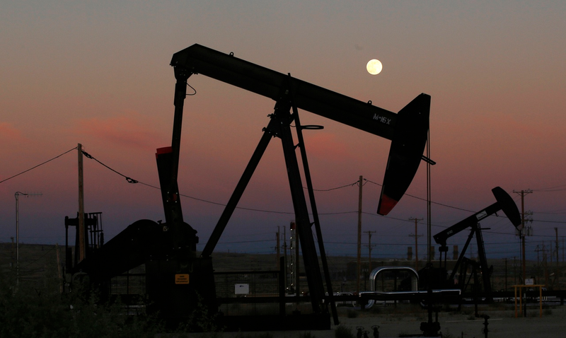 In this June 8, 2017 photo, oil derricks are busy pumping as the moon rises near the La Paloma Generating Station in McKittrick, Calif. California’s vast San Joaquin Valley. (AP Photo/Gary Kazanjian)